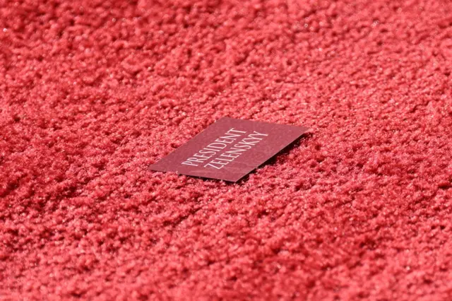 A name card bearing the name of Ukraine's President Volodymyr Zelensky is seen on a red carpet