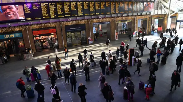 Commuters wait for trains at Kings Cross Station in London