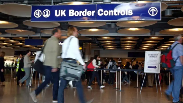 People at Border Control in Terminal Five of London's Heathrow Airport