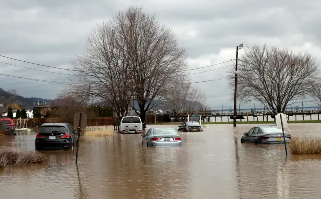 Cars sit in flood waters during a winter storm along the Hudson River shore in Piermont, New York