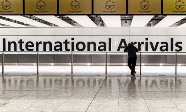 A man waits at Heathrow airport's arrival hall