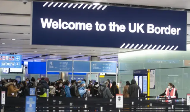 People queue at UK border control at Terminal 2 at Heathrow Airport