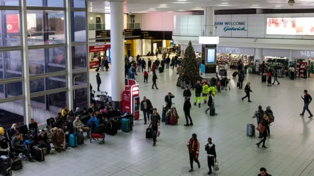 Passengers wait in the South Terminal building at London Gatwick Airport