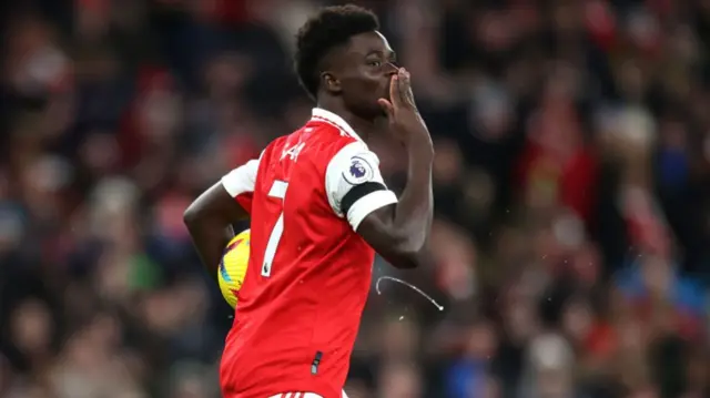 Bukayo Saka holding a football