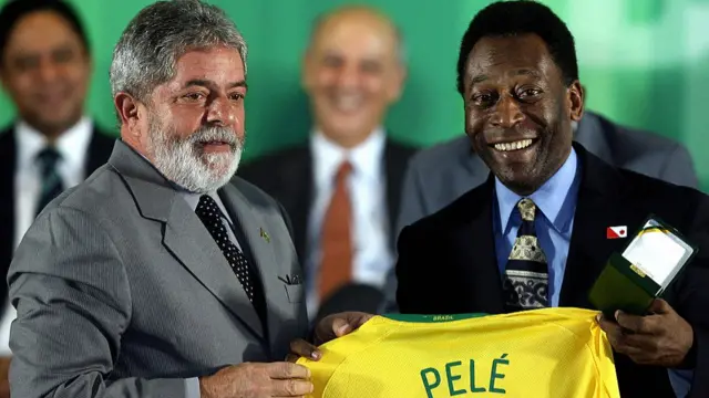 Brazilian President Luiz Inacio Lula da Silva (L) and Brazilian football legend Edson Arantes do Nacimento, known as Pele, hold a jersey during a ceremony to decorate the winners of the 1958 World Cup, in an opening ceremony of an exposition celebrating the 50th anniversary of Brazil's first victory in this tournament, at Planalto palace in Brasilia on June 26, 2008