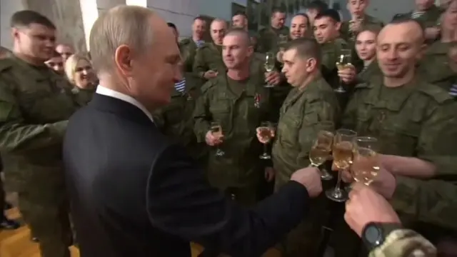 Putin clinking champagne glasses with Russian soldiers