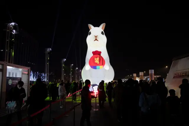 People gather near a large-scale illuminated lantern of a rabbit during New Year's Eve celebrations in Gwanghwamun square in Seoul, South Korea