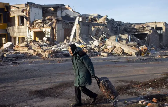 Woman in devastated street in Bakhmut, 4 December 2022