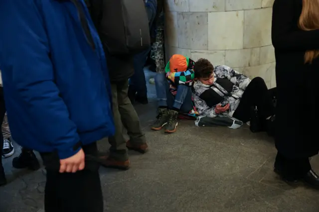 Two boys leaning on each other in the underground