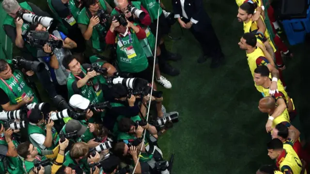 Photographers crowd the Portugal bench