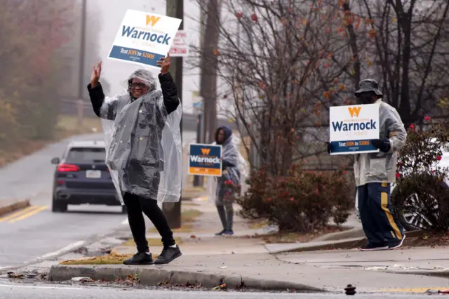 Georgia voters hold signs for Raphael Warnock