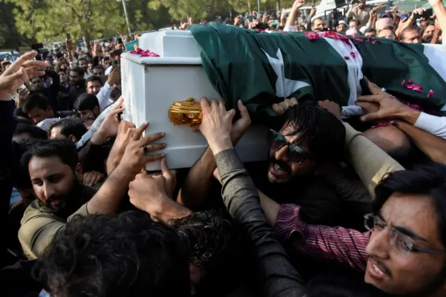 Men carry a coffin as they attend a funeral of journalist Arshad Sharif