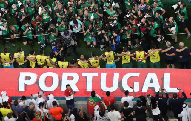 Photographers crowd the Portugal dugout