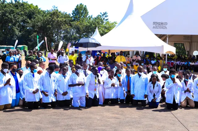 Doctors kneel before President Yoweri Museveni