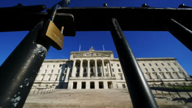 A lock appears on the gate outside Stormont