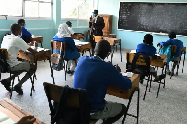 Kongoni Primary School head teacher, George Njau (back), attends to pupils inside a classroom