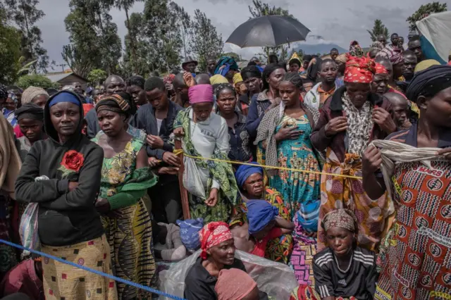 Displaced people wait for a food distribution and non-food items distributed by UNICEF to sustain them during this period of crisis in Munigi on December 5, 2022.