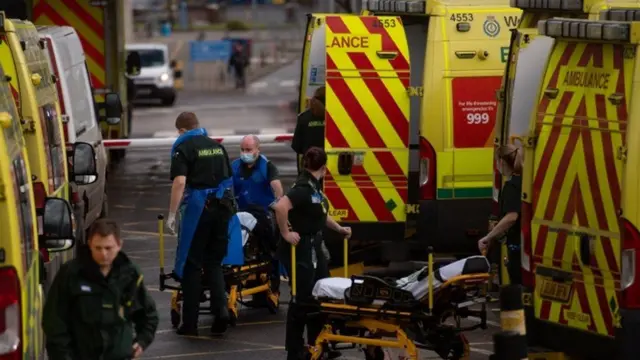 Ambulances outside hospital transferring beds and patients