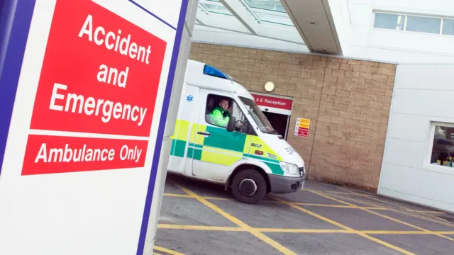 Ambulance outside an Accident and Emergency department, as it leaves a hospital