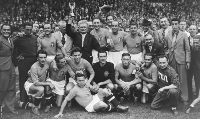 Vittorio Pozzo holds aloft the Jules Rimet trophy after Italy's 1938 World Cup win