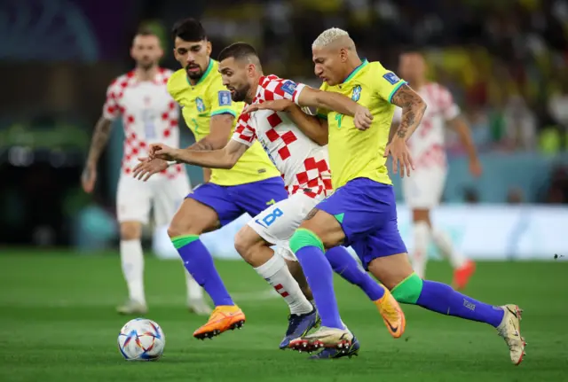 Mateo Kovacic is tackled by Richarlison and Lucas Paqueta