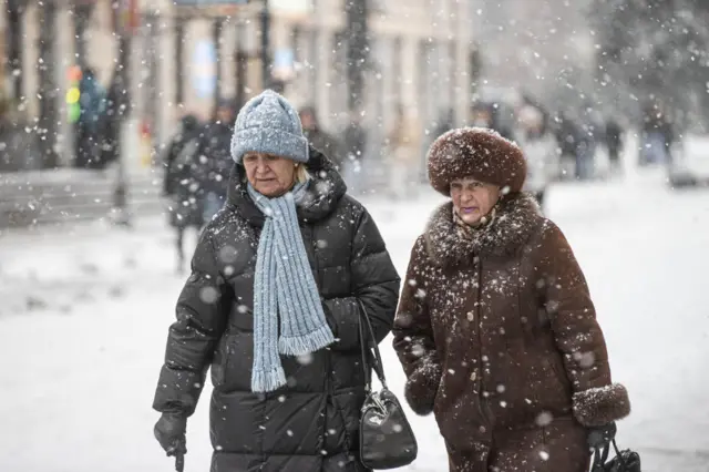 Two women walking in heavy snow in Kyiv