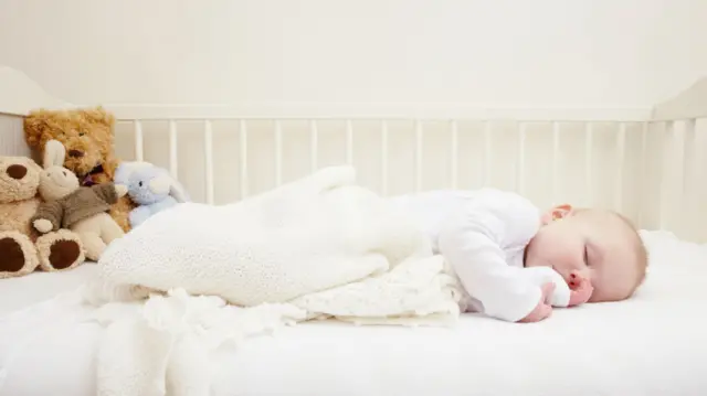 A baby asleep in a crib