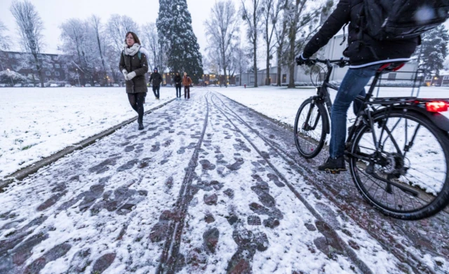 People walk in the snow in Vijen, the Netherlands