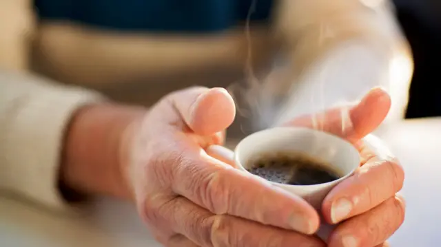 A  man holding coffee cup at table