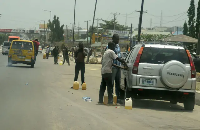 A roadside fuel vendor popularly called 'fuel tout' sell fuel from jerrycans,