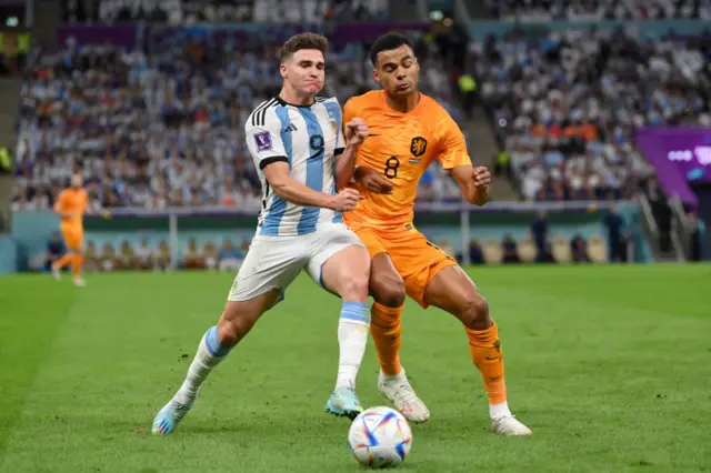 Julian Alvarez of Argentina battles for possession with Cody Gakpo