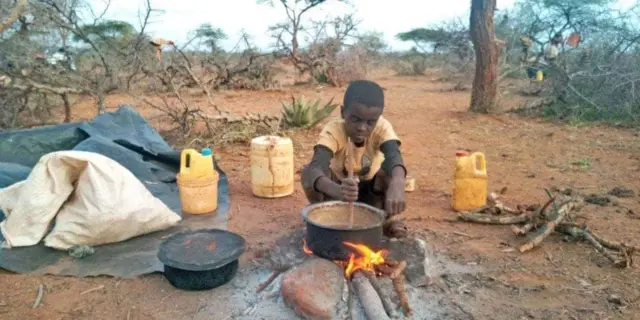 Ethiopian boy cooks food in a desert