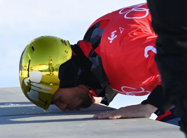 An athlete kisses the ground