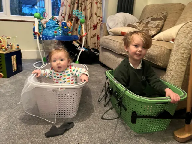 Kids in washing baskets as makeshift bobsleighs