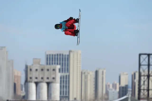 A snowboard athlete jumps high