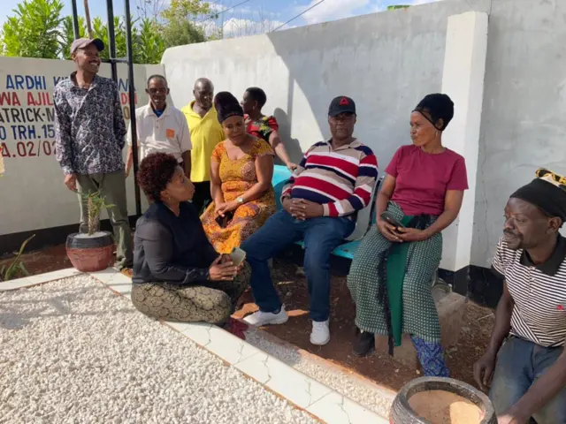 Patrick Kimaro's family sits around his grave