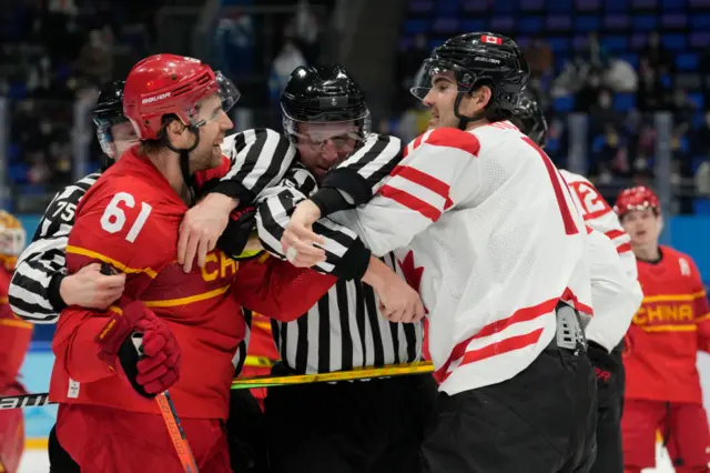 China and Canada players being split up by the referee