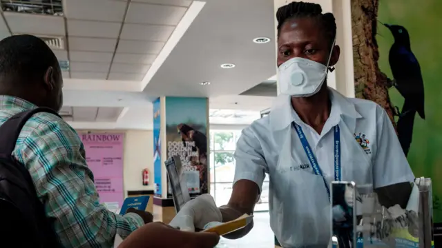 Ugandan health worker inspecting passengers in Entebbe International Airport