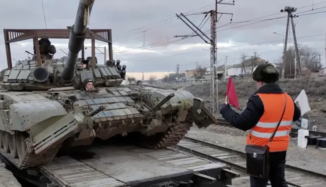 A handout still image taken from handout video made available by the Russian Defence Ministry press service shows Russian armoured fighting vehicles load on the railway freight carriages in Bakhchysarai, Crimea