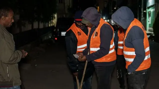 olunteers check man's identification card as they conduct night patrols in Addis Ababa, Ethiopia, on November 17, 2021.