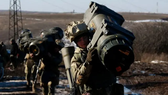 Ukrainian Armed Forces carry weapons during military drills at a firing ground in the Donetsk region