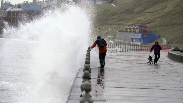 Waves crash against sea wall in Whitby