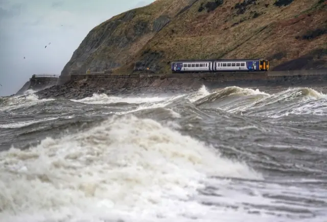 A train heads along the west coast between Whitehaven and Carlisle after Storm Dudley hit the north on Wednesday