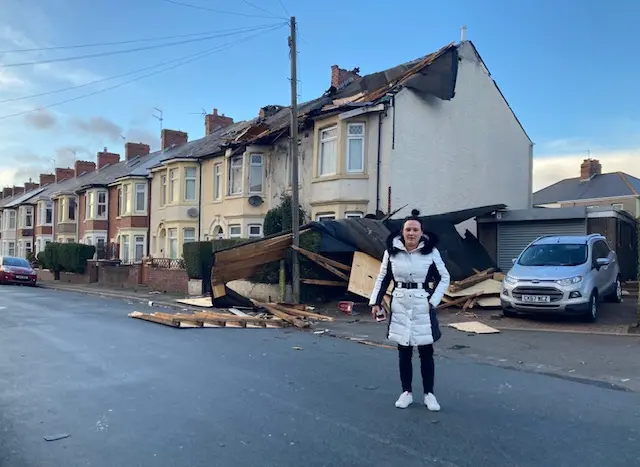 Holly Price standing in front of her damage house