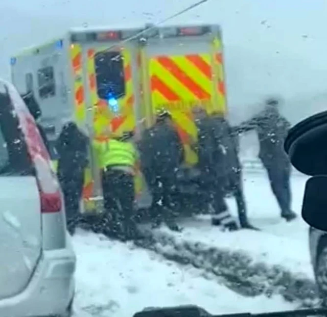 People pushing ambulance