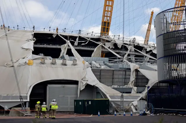 Firefighters assess the damage of the O2 from the ground