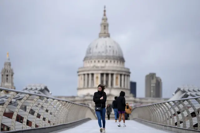 People cross the Thames near St Paul's Cathedral in London