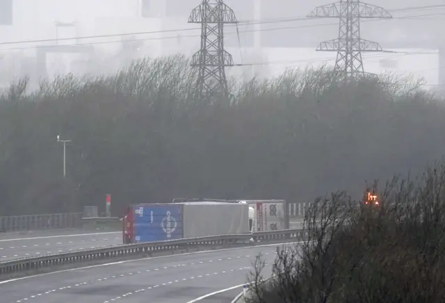 Two lorries which have been blown on their sides in the high winds, closing the M4 in Margam, south Wales