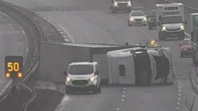 An overturned lorry straddling two lanes of the M4