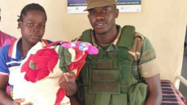 Zambian soldier Humphrey Mangisani poses with new mother her baby Raymond